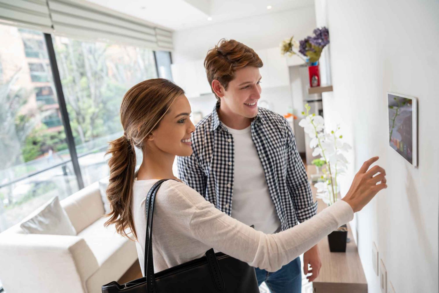 Mann und Frau schauen lächeln auf Smart-Home-Tablet